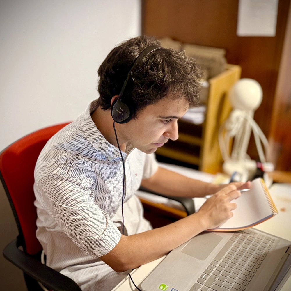 Fernando Muñoz tomando notas durante una sesión de interpretación consecutiva en una conferencia profesional.